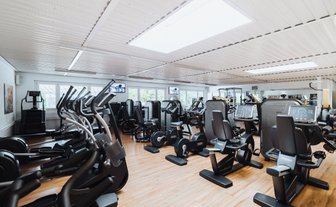 BUDGET Fitness Frick Industrie: Stimmungsbild mit Ausdauergeräten und Kraftgeräten in lichtdurchflutendem Trainingsraum.
