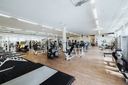 BUDGET Fitness Birrhard: Lichtdurchflutete Trainingshalle mit Kraftmaschinen, Power Rack, Kabelzügen, Ausdauergeräten, Kurzhanteln. 