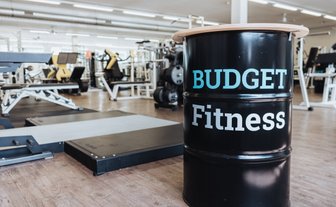 BUDGET Fitness Birrhard: Lichtdurchflutete Trainingshalle mit Power Rack von Eleiko im Vordergrund