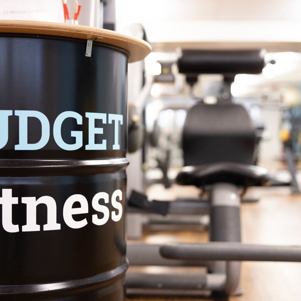 BUDGET Fitness: Stimmungsbild mit stilvollem Stehtisch auf schwarzem Stahlfass