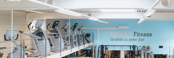 BUDGET Fitness Frick: Lichtdurchflutete Trainingshalle mit Ausdauergeräten von Precor auf der Galerie und Plate-Loaded Kraftgeräten in der Halle.