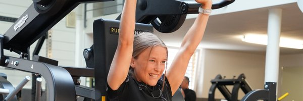 BUDGET Fitness: Stimmungsbild Trainierende an Nackendruck-Plate Loaded-Kraftmaschine von Technogym