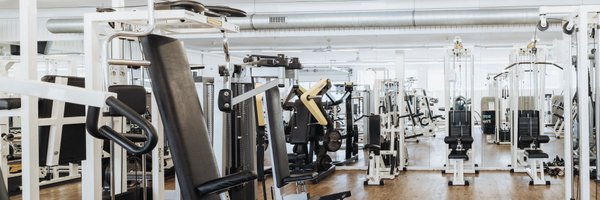 BUDGET Fitness Birrhard: Lichtdurchflutete Trainingshalle mit Kraftmaschinen, Power Rack, Kabelzügen, Ausdauergeräten, Kurzhanteln. 