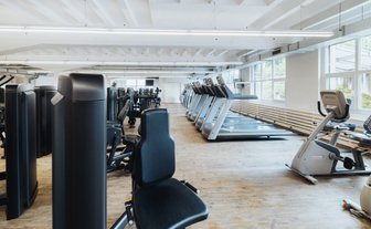 BUDGET Fitness Niederlenz: Übersicht des Trainingraumes mit Ausdauergeräten und grosser Auswahl an Kraftgeräten 
