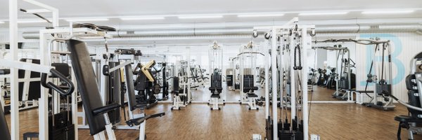 BUDGET Fitness Birrhard: Lichtdurchflutete Trainingshalle mit Kraftmaschinen, Power Rack, Kabelzügen, Ausdauergeräten, Kurzhanteln. 
