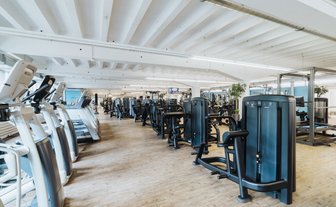 BUDGET Fitness Niederlenz: Übersicht des Trainingraumes mit Ausdauergeräten und grosser Auswahl an Kraftgeräten 